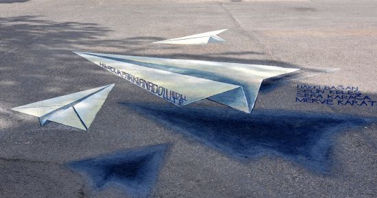 Uçan kağıt uçakları yere 3 boyutlu çizdiler
