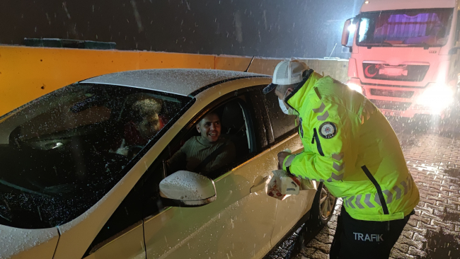 Polislerden karda güçlükle ilerleyen sürücülere çay ve simit ikramı