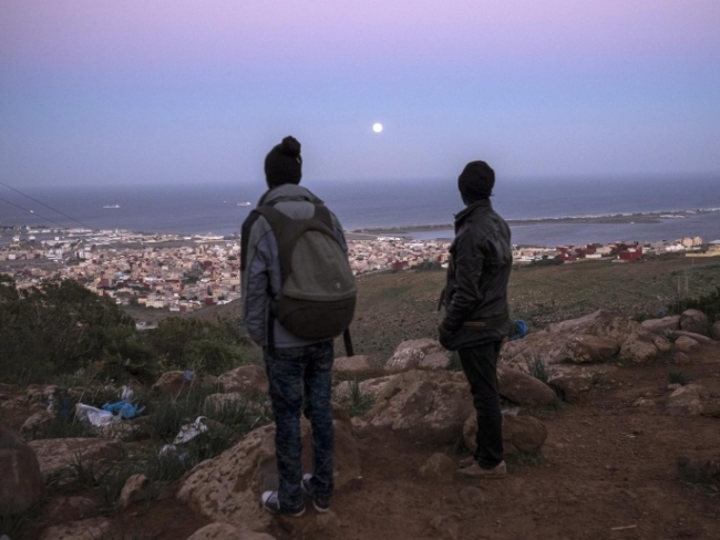 Dos inmigrantes africanos mirando a Al-Nazur, la última ciudad de camino a Europa.  Foto: AP