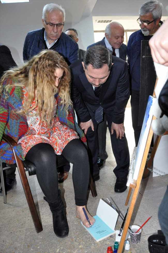 Ayaklarıyla resim çizdi, kitabını imzaladı