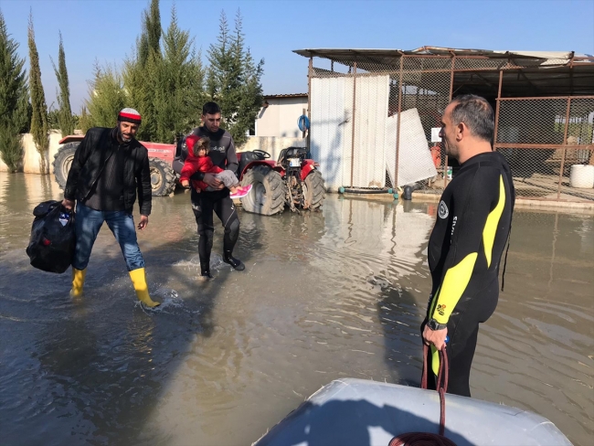 Bahçesi sular altında kalan evden botla kurtarıldılar