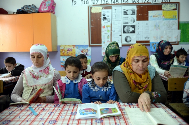 Köylüler sınıfta çocuklarıyla kitap okuyor