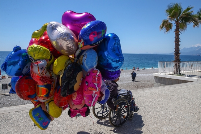 Antalya sahillerinde tekerlekli sandalyesiyle balon satıyor
