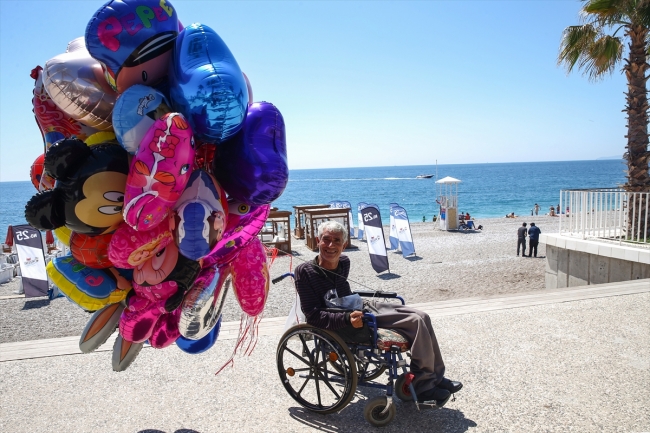 Antalya sahillerinde tekerlekli sandalyesiyle balon satıyor