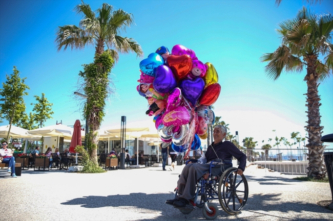 Antalya sahillerinde tekerlekli sandalyesiyle balon satıyor