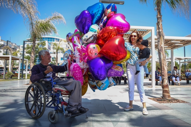 Antalya sahillerinde tekerlekli sandalyesiyle balon satıyor