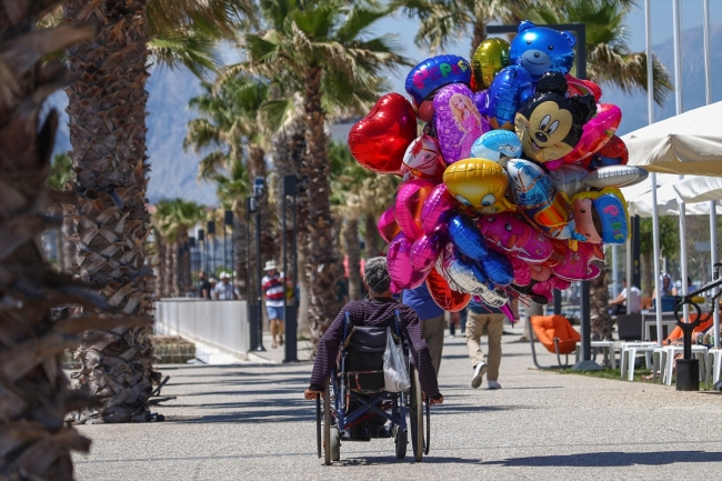 Antalya sahillerinde tekerlekli sandalyesiyle balon satıyor
