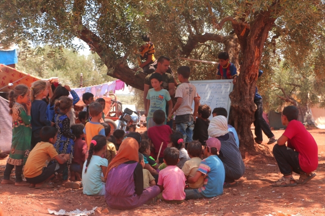 Savaş mağduru çocuklara ağaç altında eğitim veriyor
