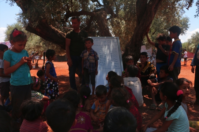 Savaş mağduru çocuklara ağaç altında eğitim veriyor