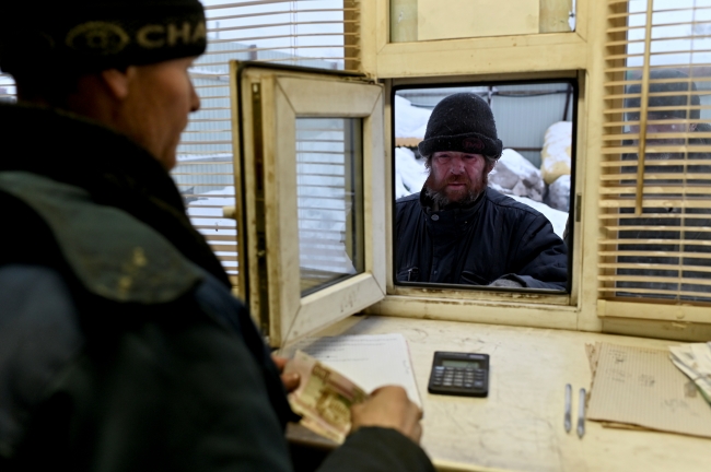 46 yaşındaki sakallı Lyokha lakaplı Alexei Vergunov geri dönüşüm merkezine getirdiği geri ürünler karşılığında ödeme almayı bekliyor. (Fotoğraf: Reuters)