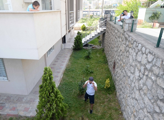 Milli sporcu sitenin bahçesinde form tutuyor