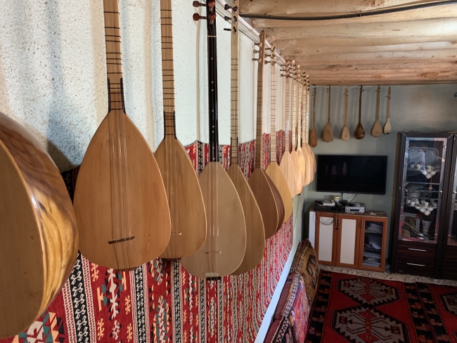 İnşaat ustası köy evindeki atölyede bağlama yapıyor