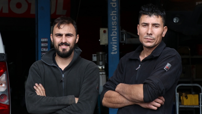 Türk tamirci Emrah Tok (sağda), başkent Paris'in Grigny bölgesinde ortağı Yusuf Bostug ile 2,5 yıl önce açtığı dükkanında araç tamir ediyor.
