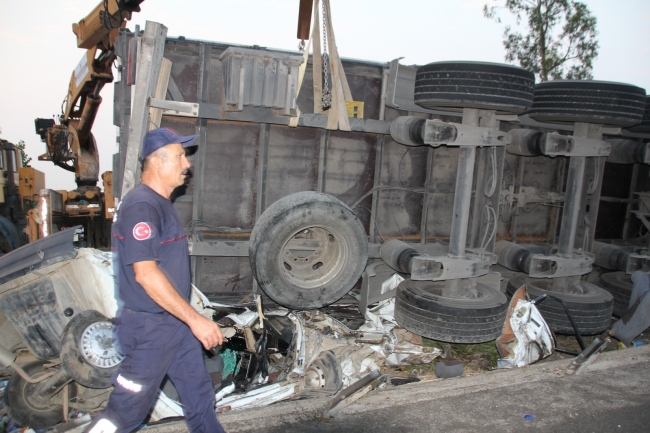 Lastiği patlayan tır otomobilin üzerine devrildi