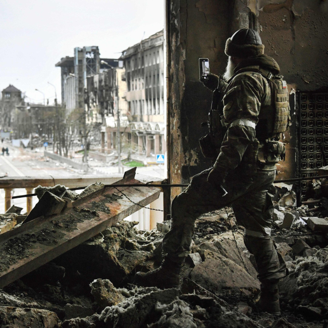 Maripol'de hakimiyet kurdukları alanları akıllı telefonuyla görüntüleyen bir Rus askeri. Foto: AFP