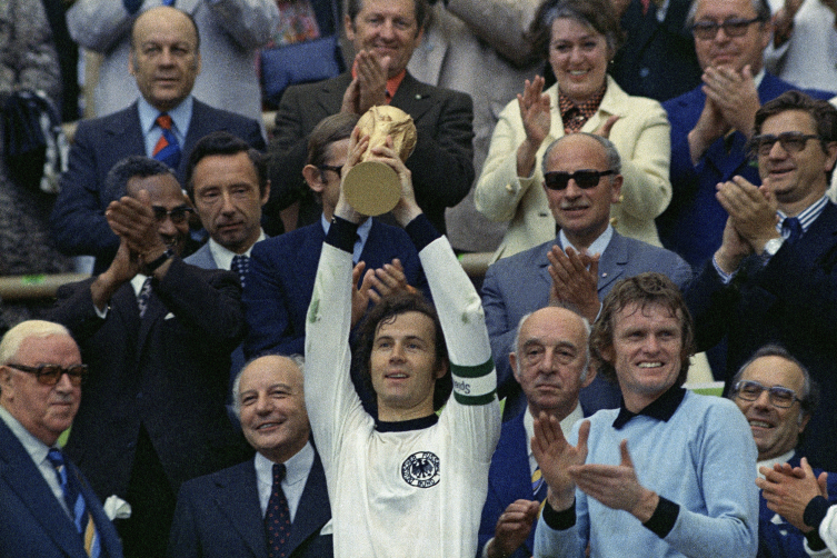 Beckenbauer, 7 Temmuz 1974'te Batı Almanya'nın Hollanda'yı 2-1 yendiği Dünya Kupası finalinde kupayı kaldırırken. (AP)
