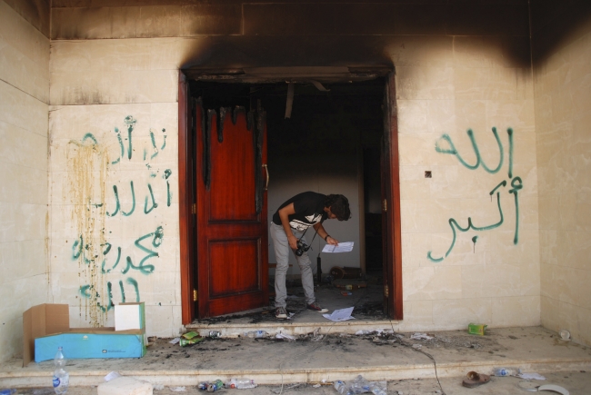 ABD'nin saldırıya uğrayan Konsolosluğunda bir kişi yanan evraklara bakıyor. Fotoğraf: AP