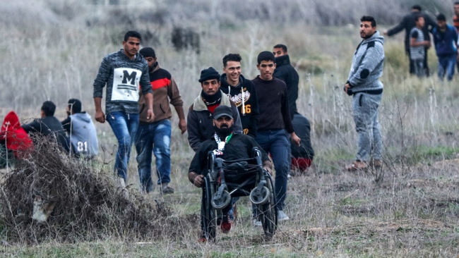 İsrail askerlerinin Gazze sınırındaki gösterilere müdahalesi sırasında bugün 29 yaşındaki Ebu Süreyya da şehit oldu. İsrail'in 2008 yılında düzenlediği saldırılarda iki bacağını kaybeden Ebu Süreyya, gösterilere tekerlekli sandalyesinde katılmaya devam etti. Fotoğrafta, Ebu Süreyya Gazze'nin doğusundaki İsrail sınırında düzenlenen bir gösteride görülüyor. Filistinli şehidin son sözleri: Bu toprak bizim, teslim etmeyeceğiz