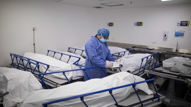 Kolombiya'da bir sağlık çalışanı koronavirüs nedeniyle hayatını kaybedenlerin bilgilerini kayıt altına alıyor. Fotoğraf: AP