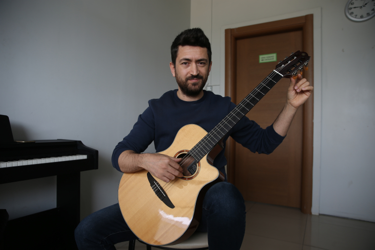 Depremden geriye kalan gitarını yanından ayırmıyor