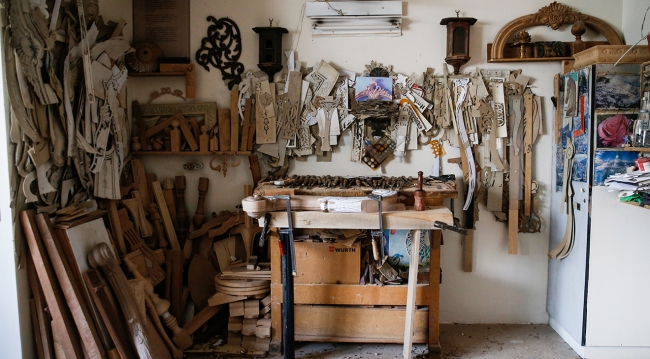 Usta hattatların yazılarını ahşaba işliyor