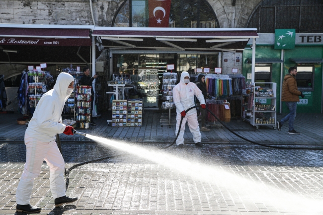 Meydanda bulunan az sayıdaki turist, dezenfekte çalışmalarını merakla izledi. Fotoğraf: AA