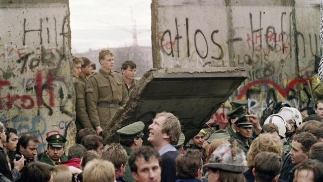 Kalabalık Berlin Duvarı'ndan ilk parçayı yıkarken, askerler yaşananları sadece izleyebiliyordu. Foto: AP