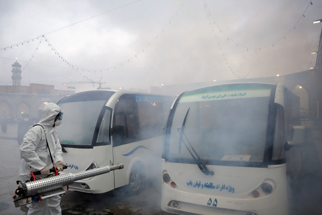 Bir görevli minibüsleri koronavirüse karşı dezenfekte ediyor. Meşhed, 29 Şubat 2020 | Fotoğraf: Reuters