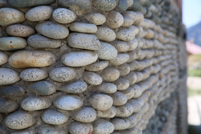 Evinin dış cephesini çakıl taşlarıyla süsledi