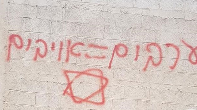 Yahudi yerleşimciler, işgal altındaki Doğu Kudüs'te Filistinlilere ait evlere ırkçı yazılar yazdı. Fotoğraf: Maan News
